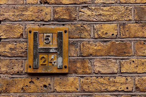 Brick wall and plaque with numbers and letter H