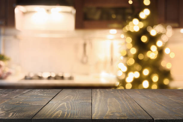 istock Wooden tabletop with cutting board and blurred modern kitchen with Christmas tree. 1285521071