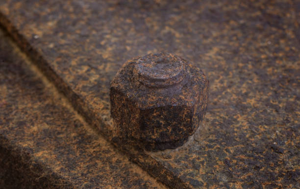 istock Old rusty large metal nut and bolt holding two metal plates together 1285522322