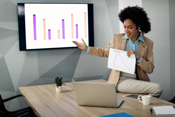 istock Happy black businesswoman talking about chart data during conference call in the office. 1285523324