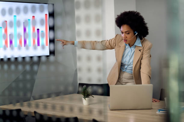 istock Black businesswoman talking about progress chart during conference call in the office. 1285523393