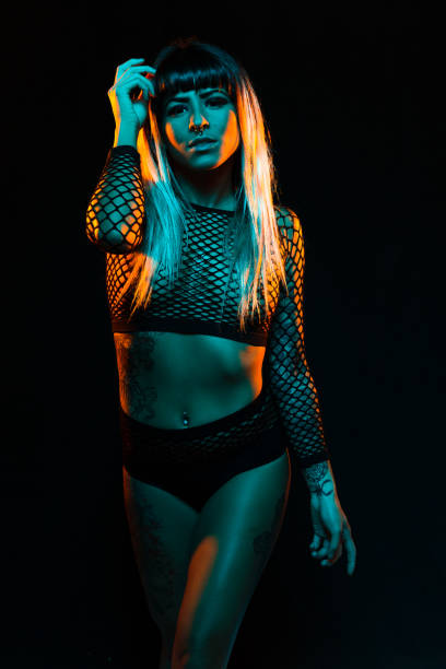 istock Young woman dances under teal and orange lights 1285523542