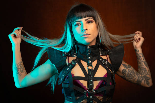 istock Young woman in leather bodysuit poses under teal side light 1285524661