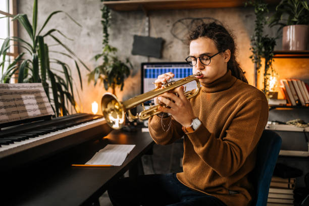 istock Young stylish musician with dreadlocks playing trumpet 1285524797