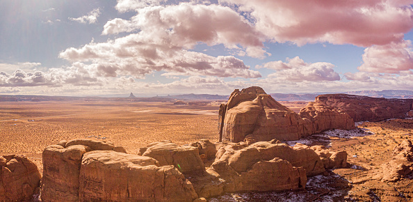 A closeup view of Delicate Arch, with snow-covered La Sal Mountains towering in background, on a clear sunny Winter day. Arches National Park, Utah, USA.