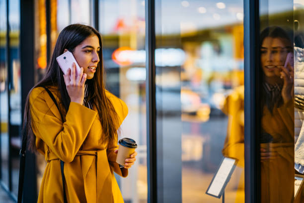 istock Woman talking on phone and window shopping 1285526020