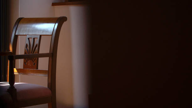 We look through a door crack to an old wooden chair