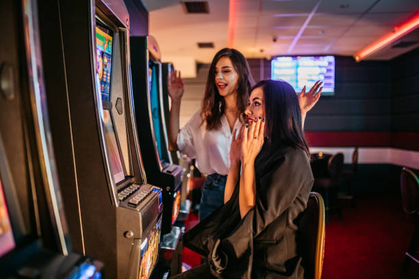 istock Friends playing on slot machines 1285527488