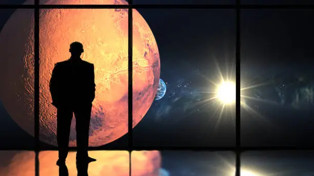 Silhouette man looking out the window at solar system planets