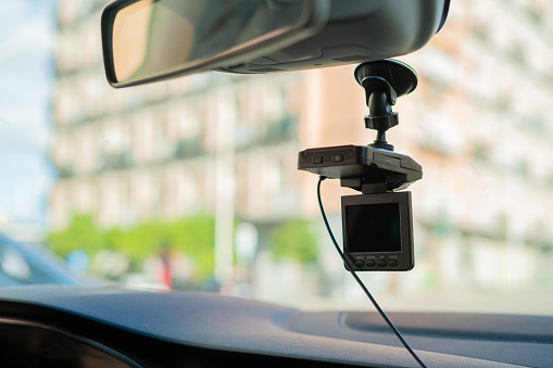 Car video camera (dash cam) inside of car on highway with blurred background of highway road, from perspective of the driver. Concept of safety camera ...