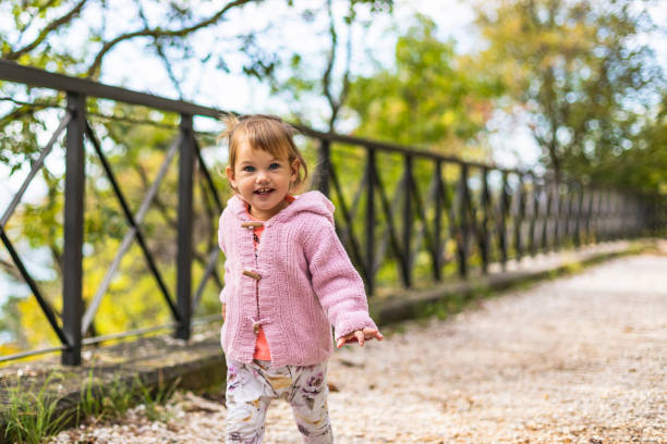 istock Joyful Small Girl Running in Public Park 1285536458