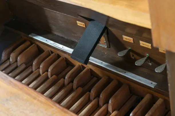 Pedalboard with pedals, swell coupler and feet controls in the pipe organ console, St. Mary's Church of Gudow, Germany, selected focus