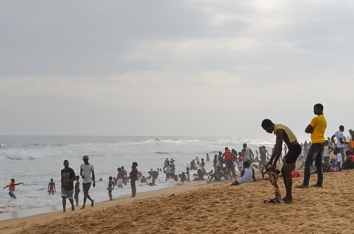 Grand-Bassam, Ivory Coast - August 16, 2015: People enjoying the beach at Grand-Bassam. The beach is a popular weekend destination for Ivorians.