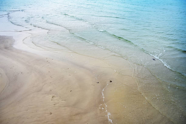 pebble coastline. Seashore with transparent water and small stones