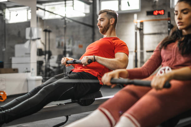 istock Young couple using rowing machine in health club 1285542876