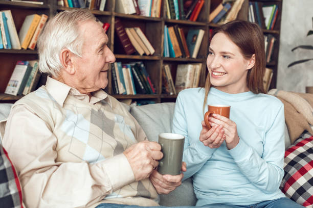 istock Father and daughter at home library sitting holding coffee cups talking happy 1285545481