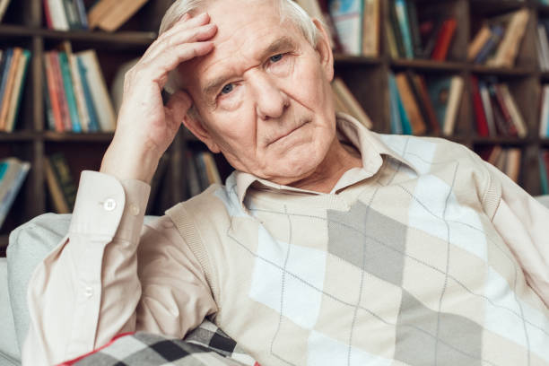 istock Senior man alone sitting at library tired 1285545487