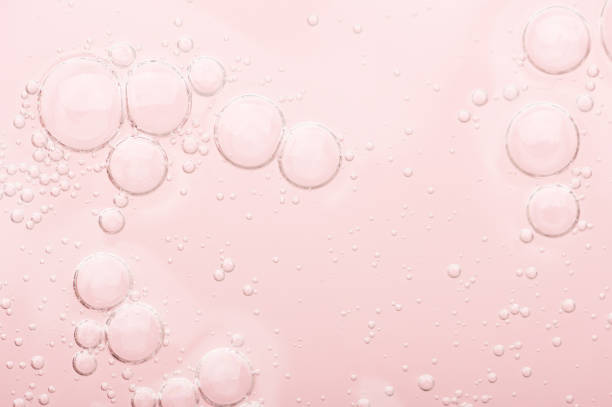 texture transparente du sérum hydratant sur un fond rose. lotion d’eau de gel pour soin de la peau. produit de beauté liquide cosmétique avec rétinol et vitamines pour les soins de la peau du visage et du corps. - prélèvement de sérum photos et images de collection