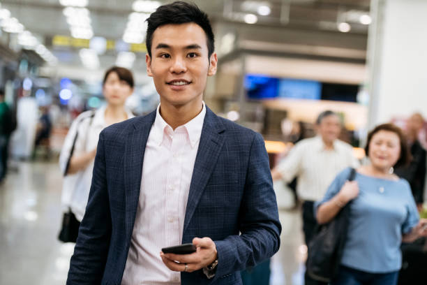 istock Mid adult businessman with smartphone smiling 1285546619