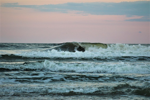 Green waves slowly creep up the jersey shore.