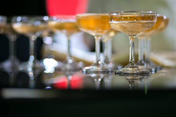 Glasses of sparkling champagne with bokeh, close up. Warm. Celebration event, holidays, drinks concept. Companion for best family or friend's memories. Anniversary, wedding day or Christmas time.
