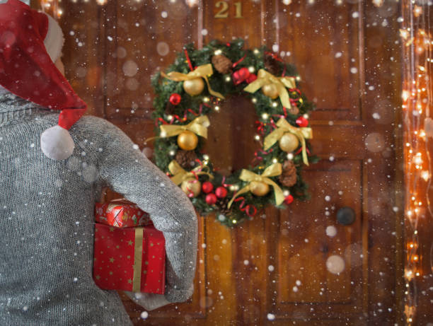 istock Female hands hold gift boxes in front of the door. Magic on Christmas night. 1285573111