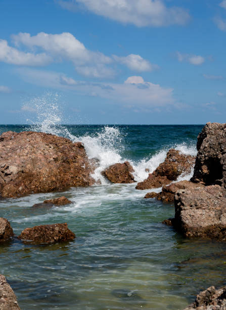 The waves crashed against the rocks by the sea stock photo