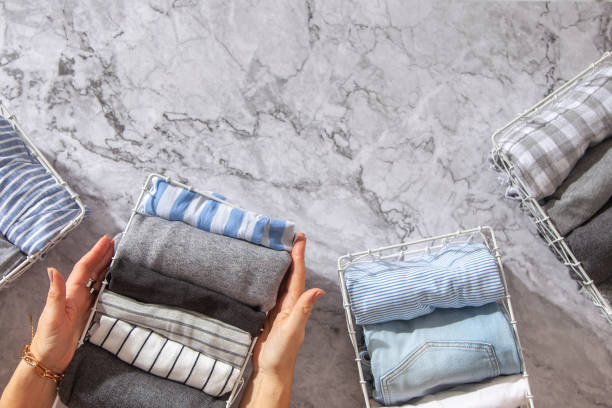 istock Neatly folded clothes and pyjamas in the metal mesh organizer basket on white marble table 1285579601