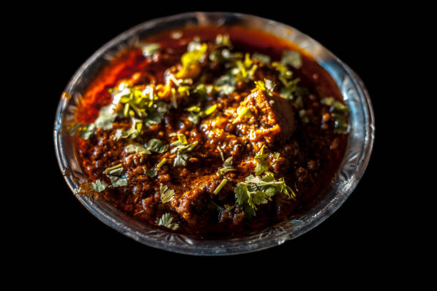 Shot of Achari Chicken along with tandoori roti with it on a serving plate with some chilies, onions, and lemons. Shot of Achari Chicken along with tandoori roti with it on a serving plate with some chilies, onions, and lemons. masala stock pictures, royalty-free photos & images