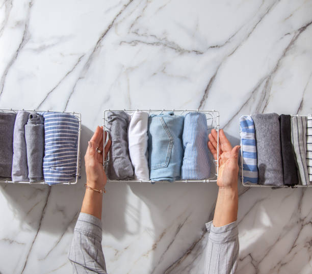 istock Neatly folded clothes and pyjamas in the metal mesh organizer basket on white marble table 1285580276
