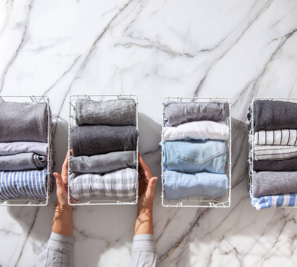 istock Neatly folded clothes and pyjamas in the metal mesh organizer basket on white marble table 1285580310
