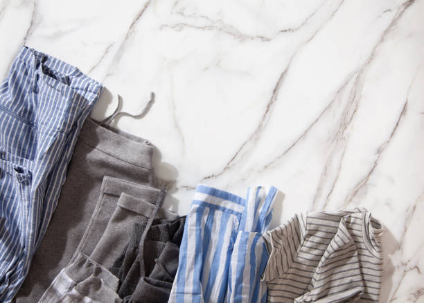 istock Group of organic cotton pyjamas set on white marble table is ready for folding and placing into white steel wire mesh baskets 1285580937