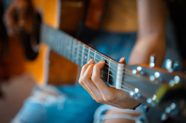 istock A woman's hand close-up picture playing acoustic guitar 1285581782