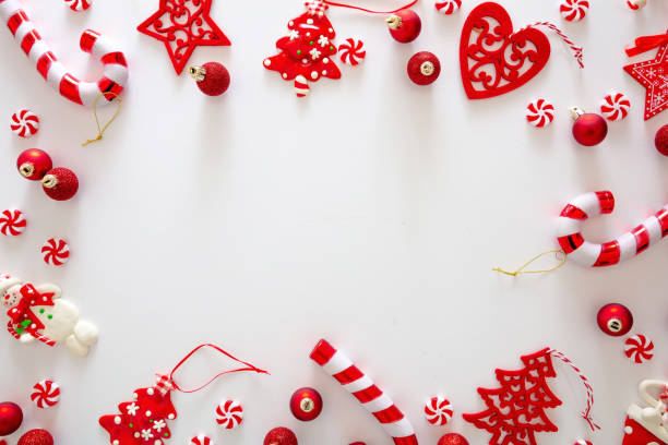istock Christmas baubles and candies flat lay against white background, xmas frame, card template 1285581835