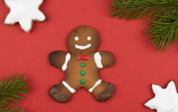 istock gingerbread men on a red background decorated with spruce branches. traditional Christmas gingerbread cookies. holiday treats handmade. top view, copy space 1285582084
