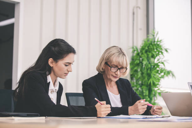 istock business partners discussing documents and ideas at meeting, Businesspeople using laptop at conference table 1285583700