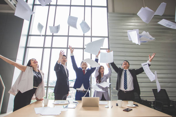 istock throw papers and documents fly in air. Success team concept after sign contract. Business people celebrating by throwing papers in the air, Happy business people celebrating success 1285583826
