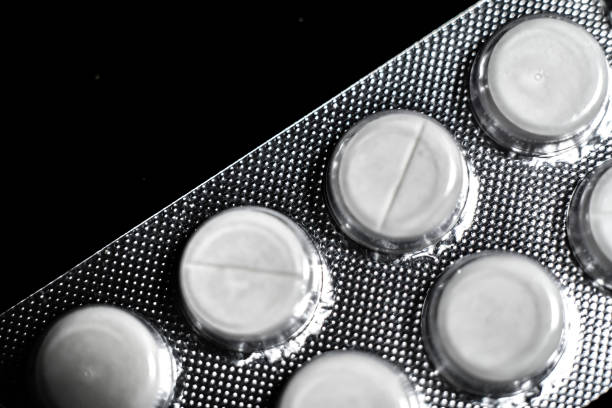 istock white tablets close up on a black background macro photo. 1285588429