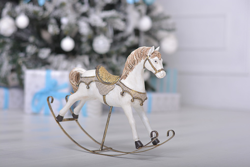 Toy horse on the background of a Christmas tree with gifts.Copy space for text