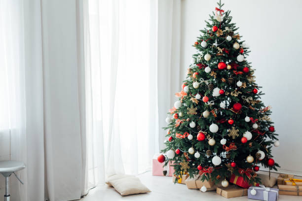 istock Christmas tree pine with gifts interior decor window new year 1285589877