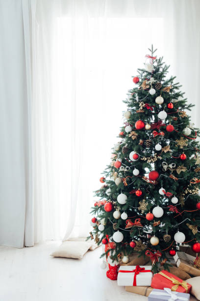 istock Christmas tree pine with gifts interior decor window new year 1285589881
