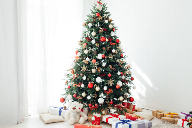 istock Christmas tree pine with gifts interior decor window new year 1285589894