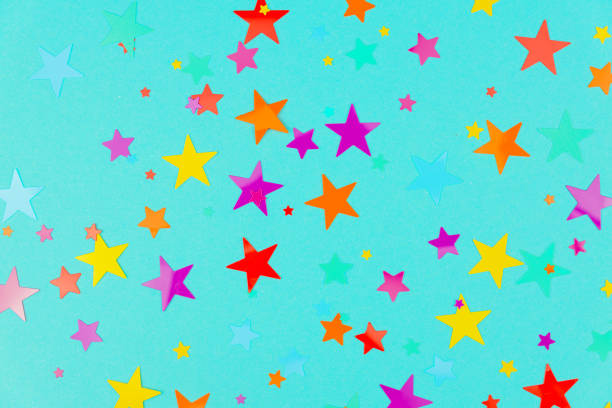 istock multicolored backdrop of colored stars confetti on a blue background. 1285593439
