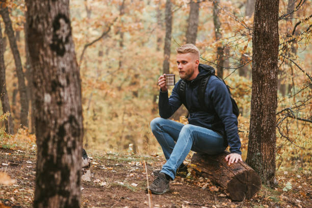 istock A man traveler in the autumn forest rests on a halt and drinks tea. 1285593706