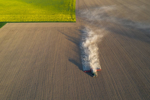 istock Farm tractor sowing plowed field, aerial view 1285597356