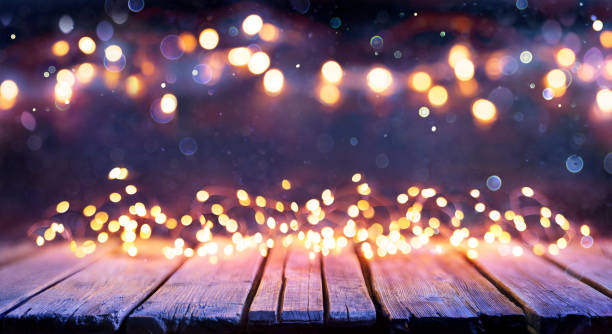 istock Abstract Christmas Background - Wooden Table With Defocused String Lights 1285600215