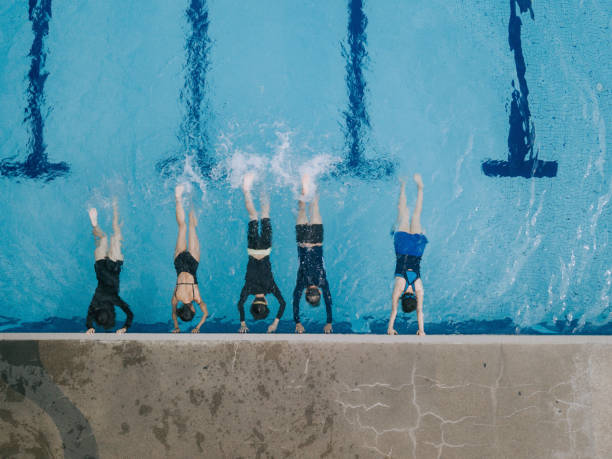 istock drone view directly above Asian chinese swimmer practicing leg splashing water at poolside guided by the swimming coach 1285601561