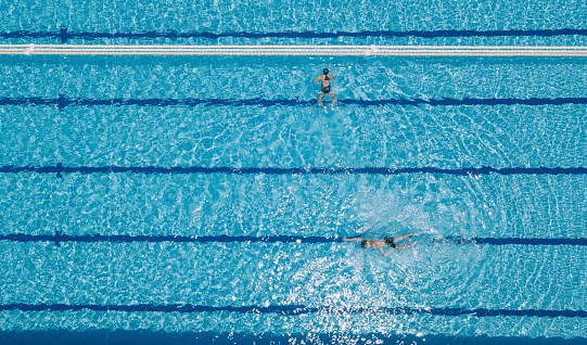 directly above drone point of view asian chinese swimmer swimming in swimming pool