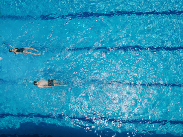 непосредственно над беспилотный точки зрения азиатских китайских пловцов плавание в бассейне - body care power swimming goggles swimming стоковые фото и изображения