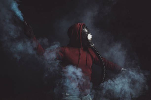 istock Man wearing gas mask holds smoke torch 1285603810